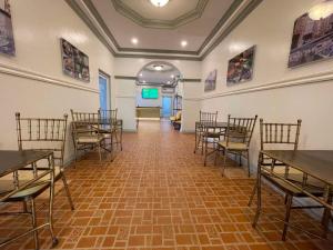 a conference room with tables and chairs and a screen at El Palacio Hotel & Resort in Cavite