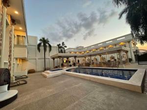 a large house with a swimming pool in front of it at El Palacio Hotel & Resort in Cavite