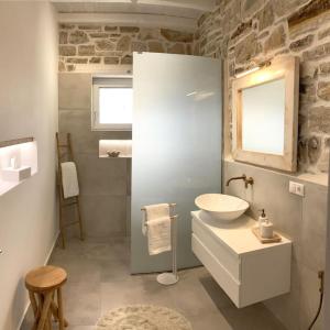een badkamer met een wastafel, een toilet en een spiegel bij VILLA LEVANTA - Das ideale Wohlfühl-Refugium Aussicht, Komfort, Erholen, Home Office in Pitsidia +31 foto's