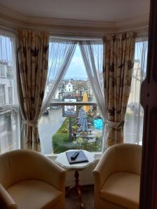 ventana con 2 sillas y vistas al río en Virginia Cottage Guest House, en Bowness-on-Windermere