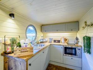 a kitchen with white cabinets and a sink and a window at Heather - Uk34841 in Straiton