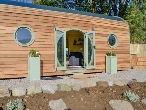 a tiny house with a large sliding door and windows at Heather - Uk34841 in Straiton