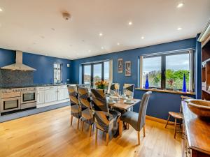 a dining room with blue walls and a table and chairs at Highfields in Runswick
