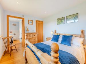 a bedroom with a wooden bed with blue pillows at Highfields in Runswick