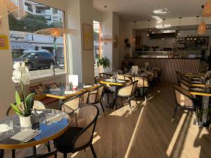 une salle à manger avec des tables et des chaises dans un restaurant dans l'établissement Hotel Marcellin, à Beaulieu-sur-Mer