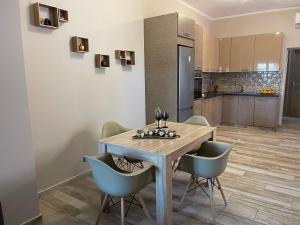 a kitchen and dining room with a wooden table and chairs at Apartment Belle Epoque in Lixouri