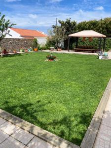 シントラにあるCasa da Monserviaのガゼボと緑の芝生がある広い庭