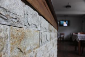 a brick wall with a dining room in the background at Guest House Veni in Blagoevgrad