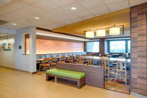 a restaurant with a long bar with wooden tables and chairs at Fairfield Inn & Suites by Marriott Columbus Dublin in Dublin