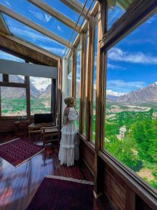 a woman standing in a room with a large window at Old Hunza inn in Hunza Valley
