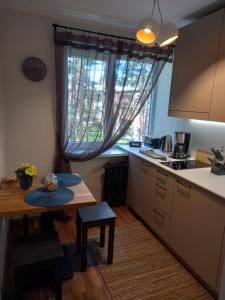 eine Küche mit einem Tisch, einem kleinen Tisch und einem Fenster in der Unterkunft Zvejnieku apartamenti in Roja