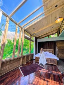 a bedroom with a bed in a room with windows at Old Hunza inn in Hunza Valley