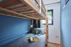 a small bedroom with a bunk bed with blue walls at Family Friendly, self contained, Bed and Breakfast with private hot tub in Laugharne