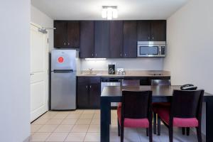 a kitchen with a table and chairs and a refrigerator at TownePlace Suites by Marriott Charlotte Mooresville in Mooresville