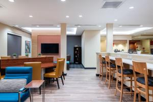 a waiting room with a bar and chairs at TownePlace Suites by Marriott Charlotte Mooresville in Mooresville