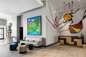 a living room with a couch and a painting on the wall at The MC, Autograph Collection in Montclair