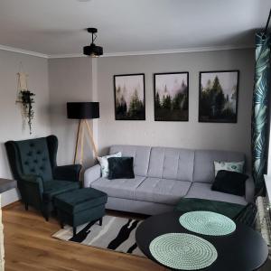 a living room with a couch and a table and chairs at Apartament Kościuszki in Sanok