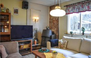 een woonkamer met banken en een flatscreen-tv bij Cozy Home In Sknes Fagerhult With Kitchen in Skånes Fagerhult