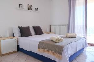 ein Schlafzimmer mit einem großen Bett mit Handtüchern darauf in der Unterkunft Vila Nada in Prigradica