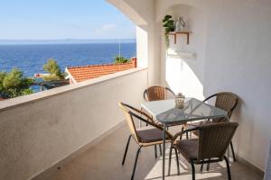 einen Tisch und Stühle auf einem Balkon mit Meerblick in der Unterkunft Vila Nada in Prigradica