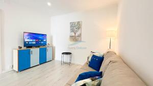 ein Wohnzimmer mit einem Sofa und einem Flachbild-TV in der Unterkunft Casa da Quinta by Sunny Deluxe in Cabeção