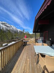 una terraza de madera con mesa y sillas. en Peaceful cottage close to Bø Sommarland and Lifjell-perfect for hiking 