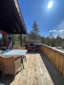 un patio con tavolo e sedie su un ponte di Peaceful cottage close to Bø Sommarland and Lifjell-perfect for hiking a Folkestad