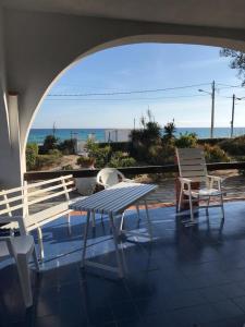 a table and chairs on a patio with a view of the ocean at MareDentro in Mazara del Vallo