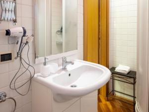 - Baño con lavabo blanco y secador de pelo en B&B Casa Decimo, en Greve in Chianti