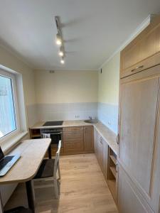 a kitchen with a wooden table and a table and a dining room at Ruses. One Bedroom Apartment in Rīga