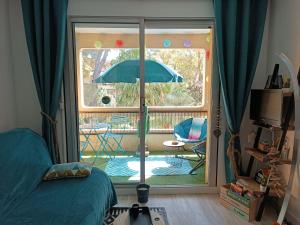a bedroom with a sliding glass door with an umbrella at Studio Paradise entre mer et pins in Saint-Raphaël