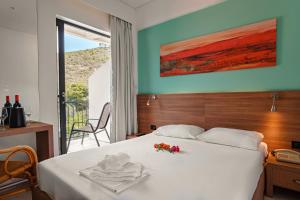 a bedroom with a bed with flowers on it at Hotel Pavlou in Poros