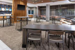 a bar with tables and chairs in a restaurant at SpringHill Suites Atlanta Alpharetta/Roswell in Roswell