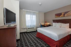 a hotel room with a bed and a flat screen tv at TownePlace Suites by Marriott Boise Downtown/University in Boise