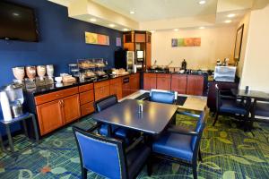 a restaurant with tables and chairs and a kitchen at AmericInn by Wyndham Topeka in Topeka