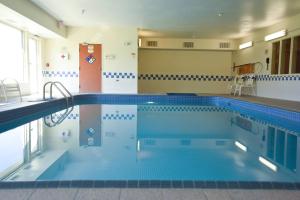 a large swimming pool in a building at AmericInn by Wyndham Topeka in Topeka