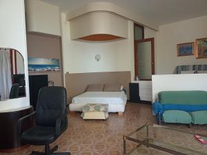 サレルノにあるVerde Smeraldoのベッドルーム1室(ベッド1台、ソファ、椅子付)