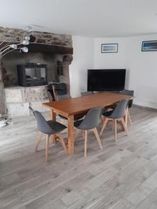 una mesa de madera y sillas en una habitación con chimenea en Maison de 3 chambres avec jardin clos et wifi a Quettehou, en Quettehou
