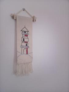 a drawing of a lighthouse hanging on a wall at Lindita's Seaview Appartment in Vlorë