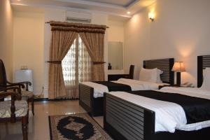 Postel nebo postele na pokoji v ubytování Hotel de Raj Sialkot