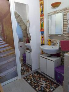 a bathroom with two sinks and a mirror and stairs at The little house of Ely in Siracusa