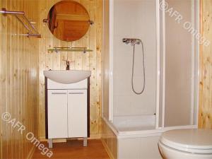 y baño con lavabo blanco y ducha. en Domki Letniskowe Pikamar en Darlowko