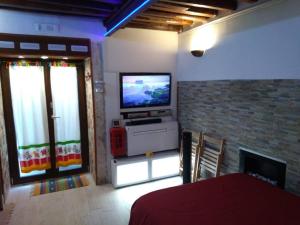 a living room with a television and a fireplace at The little house of Ely in Siracusa