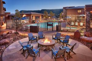 eine Terrasse mit Stühlen und einer Feuerstelle im Hof in der Unterkunft Residence Inn by Marriott Sedona in Sedona