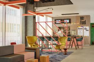 a lobby with a table and chairs and a staircase at Aloft Birmingham Eastside in Birmingham