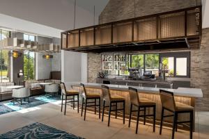 a kitchen with a bar with chairs and a table at Residence Inn By Marriott Jacksonville-Mayo Clinic Area in Jacksonville