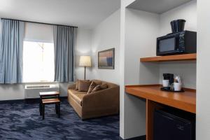 a hotel room with a couch and a tv at Fairfield Inn & Suites by Marriott Wichita Downtown in Wichita +15 photos