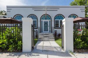 a white house with a blue door at Vive Zen Queen Room in Miami