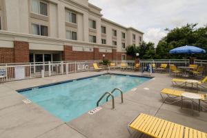 a pool with tables and chairs in front of a building at Fairfield Inn Hartsville in Hartsville