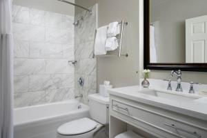 a white bathroom with a sink and a toilet and a tub at Marriott Vacation Club Pulse at Custom House, Boston in Boston